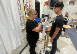  student checks weight of older student on manual scale